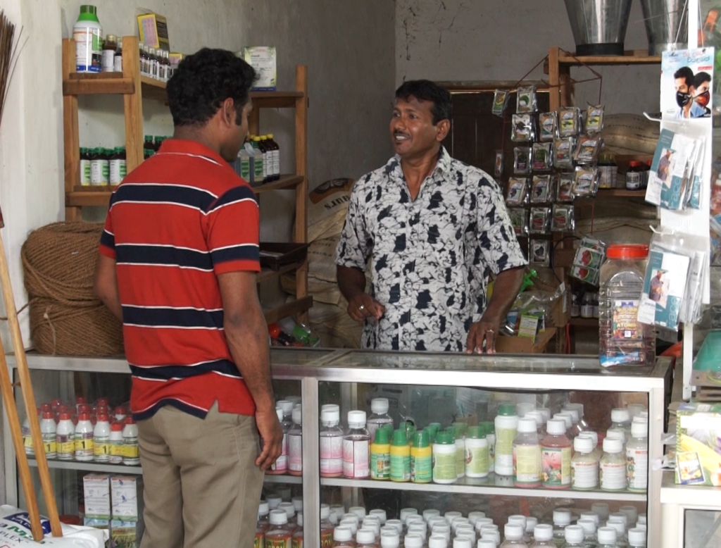 Man speaking to a pesticide vendor in Sri Lanka