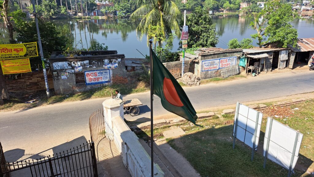 National flag of Bangladesh attached to a flagpole, flying in the wind